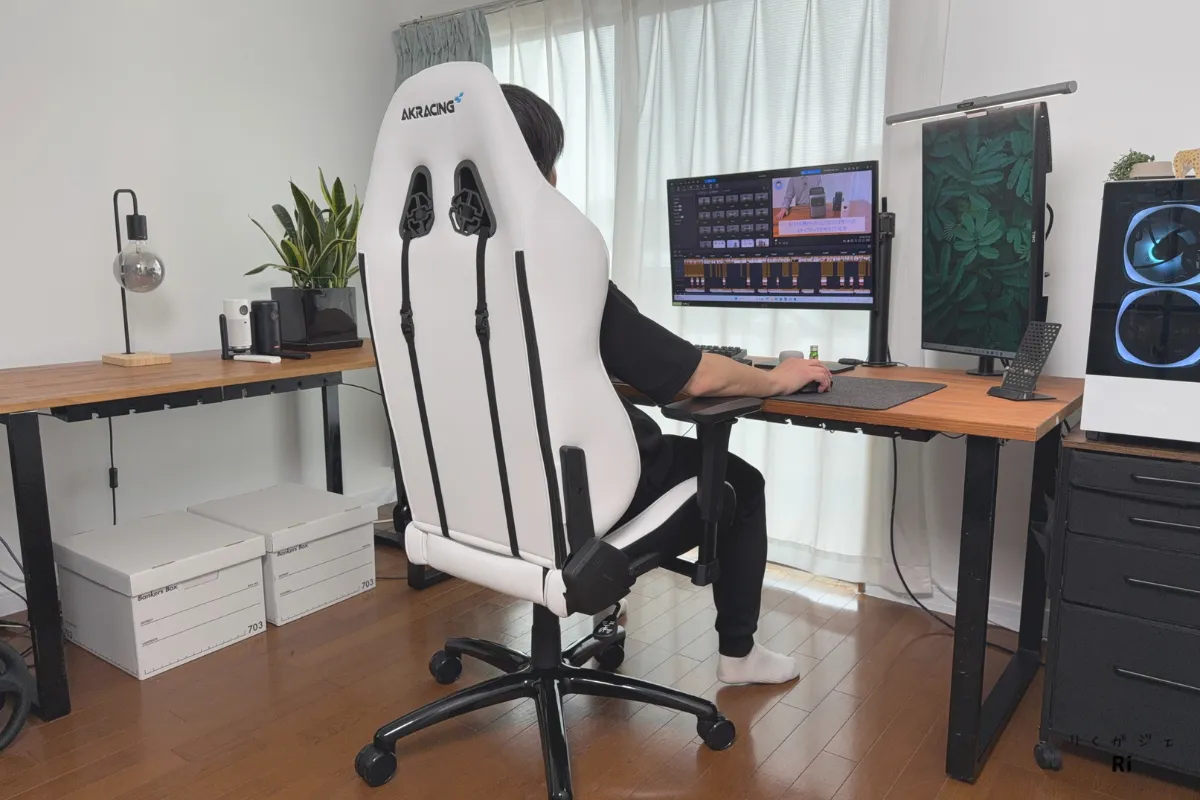AKRacing Eclairに着座してデスクワークを行う男性の作業風景|長時間作業でも快適な座り心地と背面デザインが特徴のゲーミングチェア