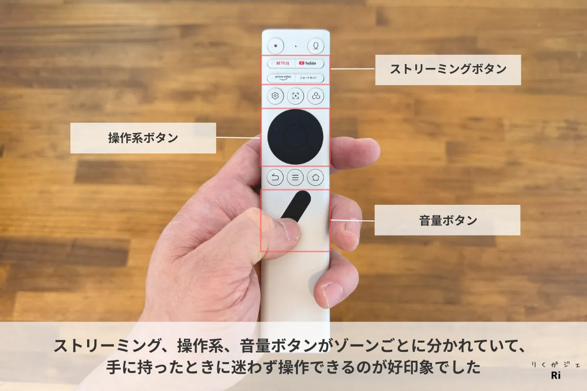 Aladdin Poca LaserのBluetoothリモコンを手に持って操作している様子。ストリーミング、操作系、音量ボタンがゾーンごとに配置されており、直感的に操作できるデザイン。