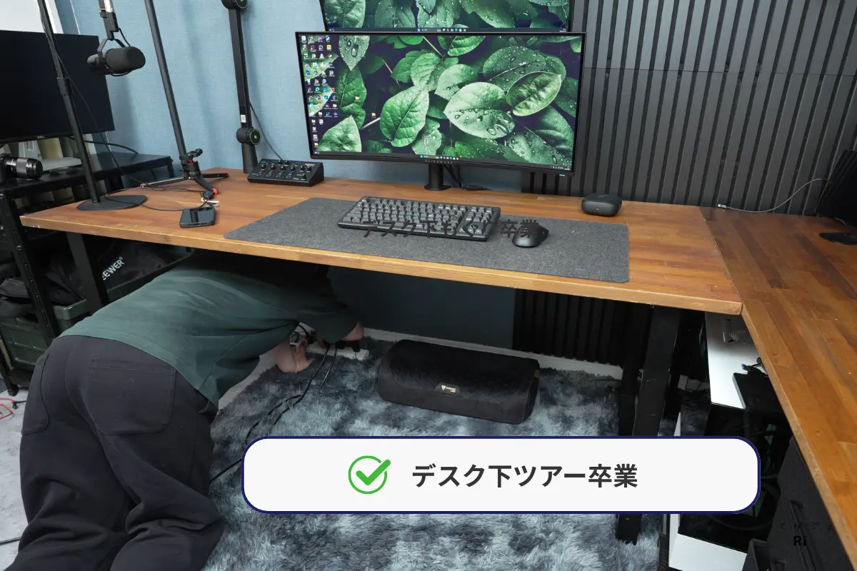 デスク下で電源タップを探す様子