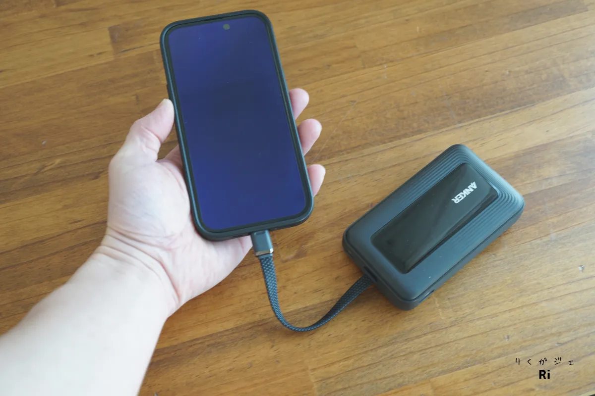 Anker Zolo Power Bank（10000mAh, 30W）の内蔵USB-Cケーブルでスマートフォンを充電している様子。ケーブル長は実測で約25cm、片手操作にも対応可能な長さ。