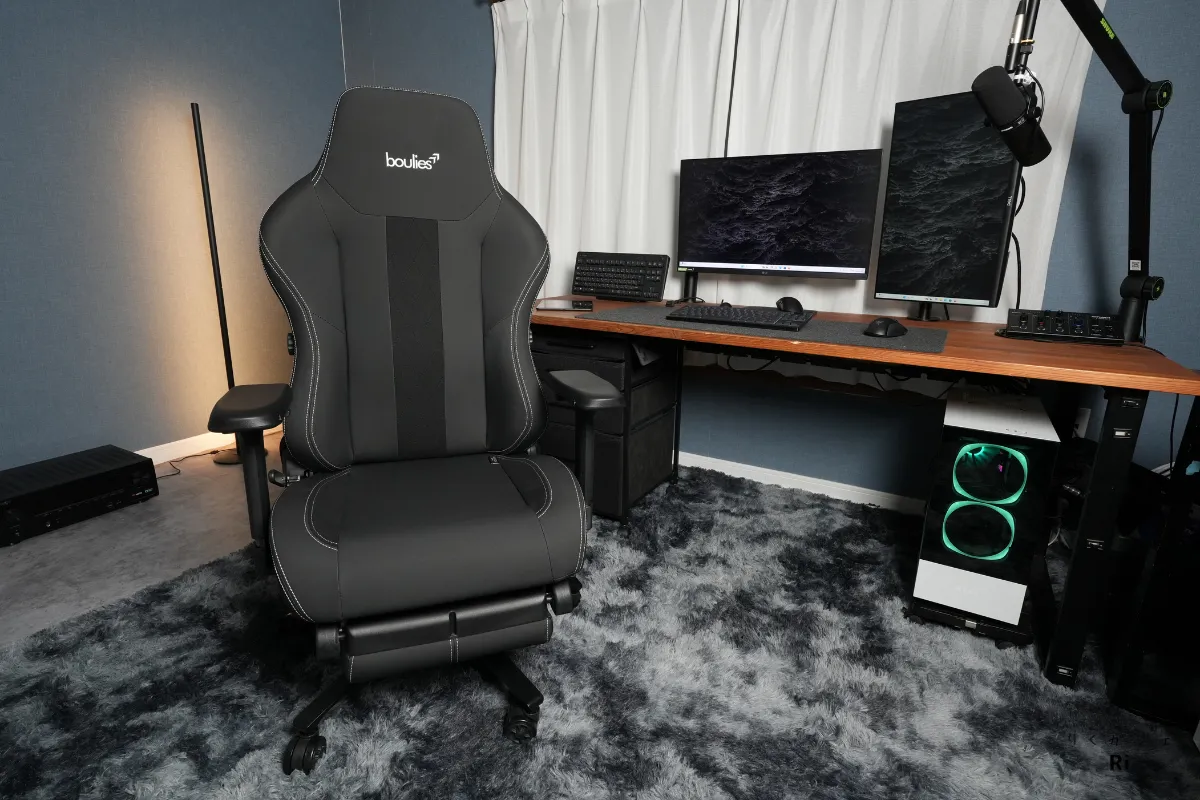 Boulies Master Rex がデスク環境に設置された様子。ゲーミングデスク、モニター、照明に囲まれた落ち着いた部屋で、高級感あるデザインと存在感が際立つ