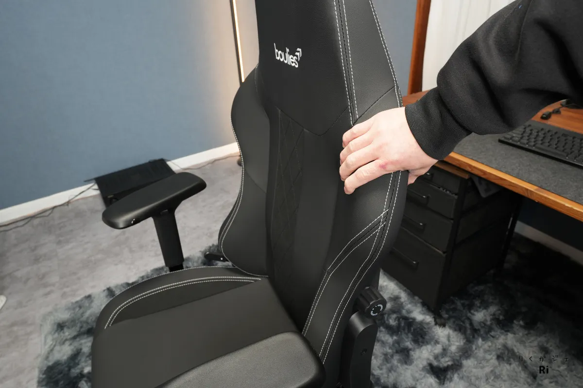 Boulies Master Rex の背もたれを手で押してクッション性を確認している様子