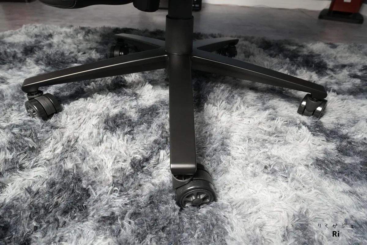 ゲーミングチェアのキャスターとアルミ製スターベースを床面から撮影した写真。カーペット上でもスムーズに動く様子を示す