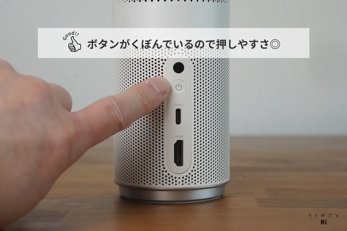 Anker Nebula Capsule Airの背面にある電源ボタンを指で押している様子。ボタンが凹んでおり、押しやすい形状になっている。