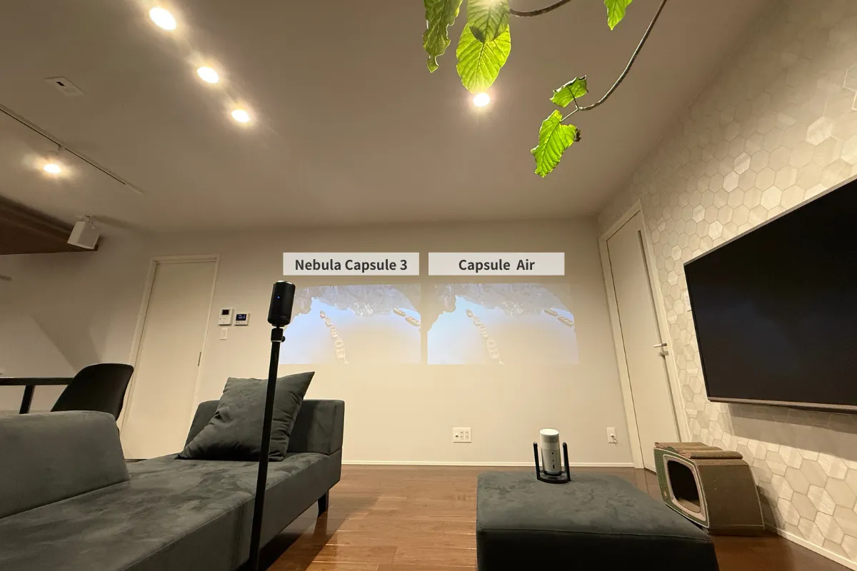 Nebula Capsule 3とCapsule Airの明るさを、照明を全灯にした明るいリビング環境で比較している様子。両モデルとも壁紙への投影が薄く、映像の視認性はかなり低下している。