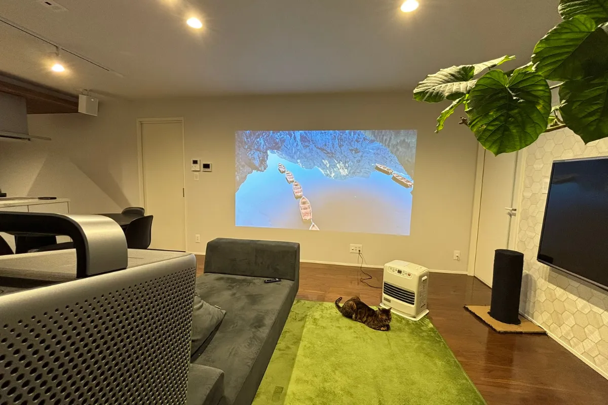 Nebula Cosmos 4K SEを使用し、照明をつけた室内での映像投影テスト。壁に大画面で映像を投影している様子。