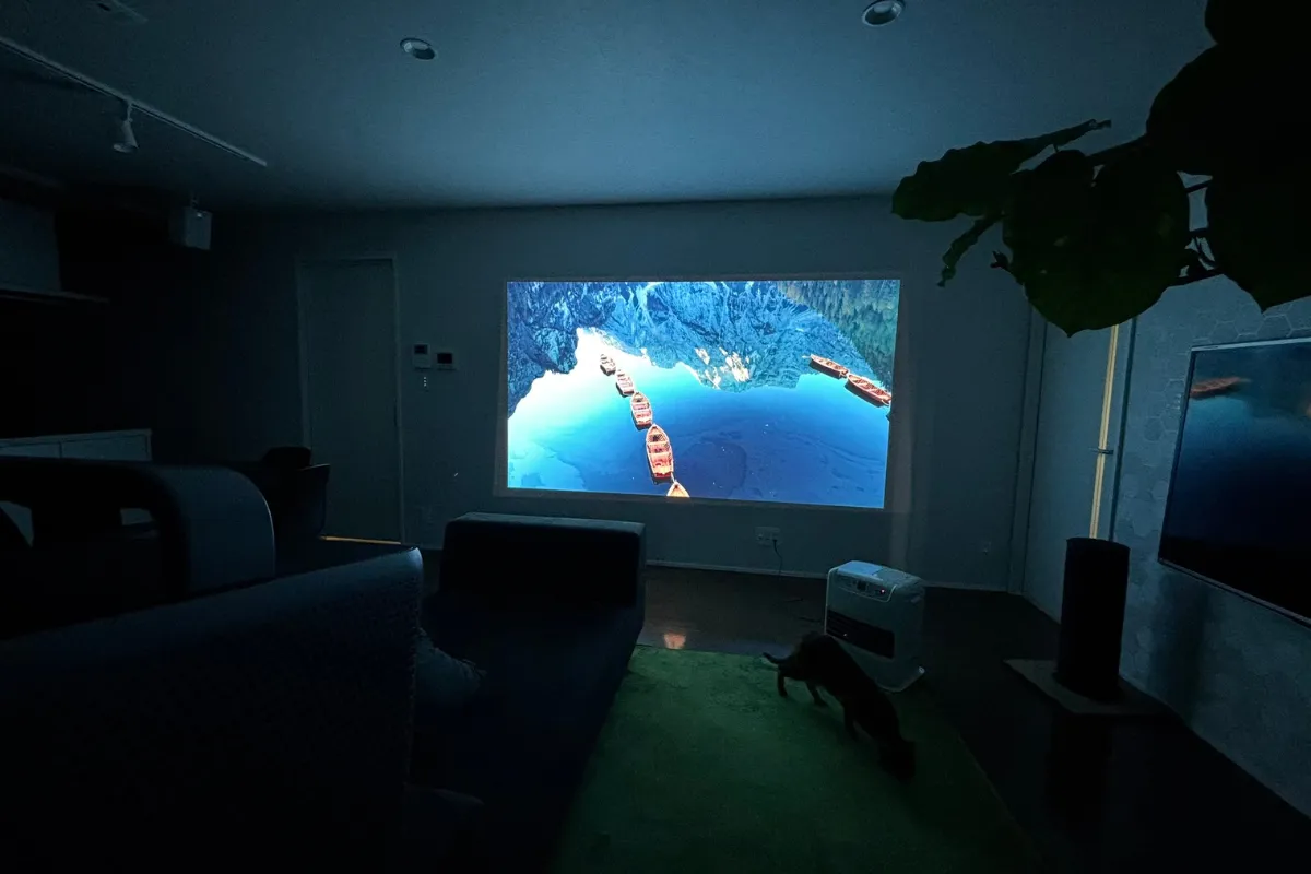 夜間のリビングでNebula Cosmos 4K SEが壁に明るく映像を投影している様子。部屋の照明は消えており、映像の明るさとコントラストが際立っている。