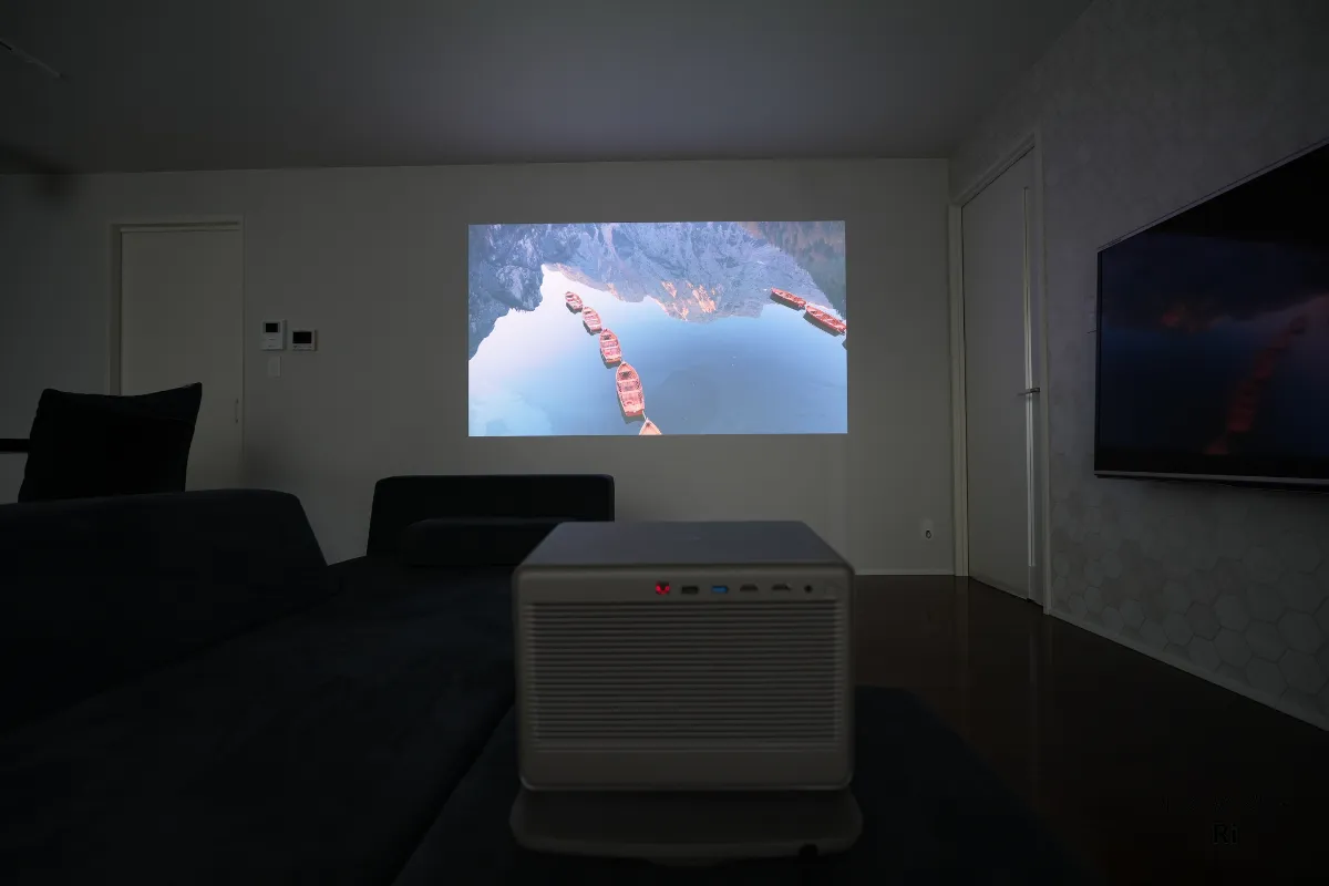 間接照明がある薄暗い室内でプロジェクター映像を投影している様子を写した写真
