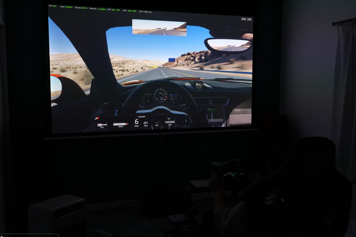 240Hz対応環境でレースゲームを大画面投影しながらプレイしている様子を撮影した写真
