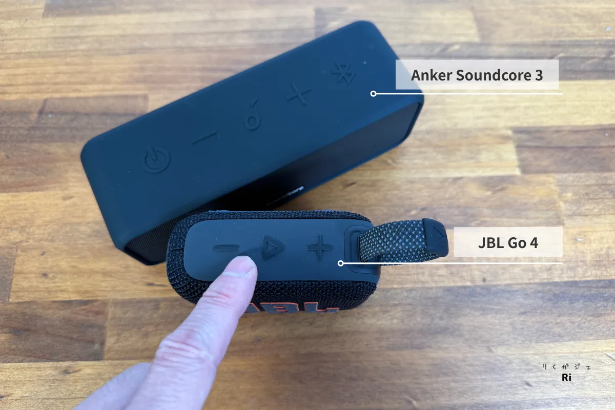 JBL Go 4とAnker Soundcore 3の比較。JBL Go 4上部の操作ボタンとストラップが写っており、グレー寄りのゴム素材で汚れが目立ちにくいデザイン