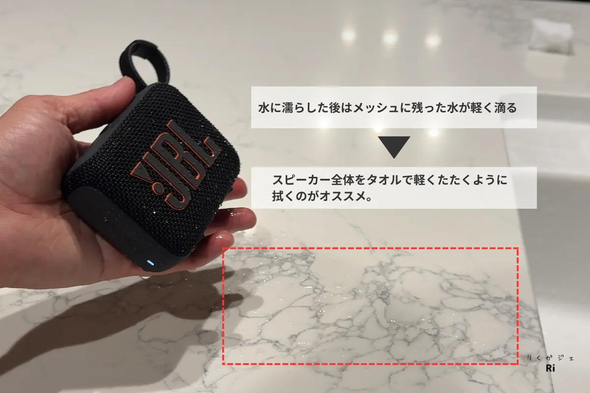 JBL Go 4を水に濡らした後、メッシュ部分に残った水が軽く滴る様子。タオルで拭き取ることがおすすめと解説している写真