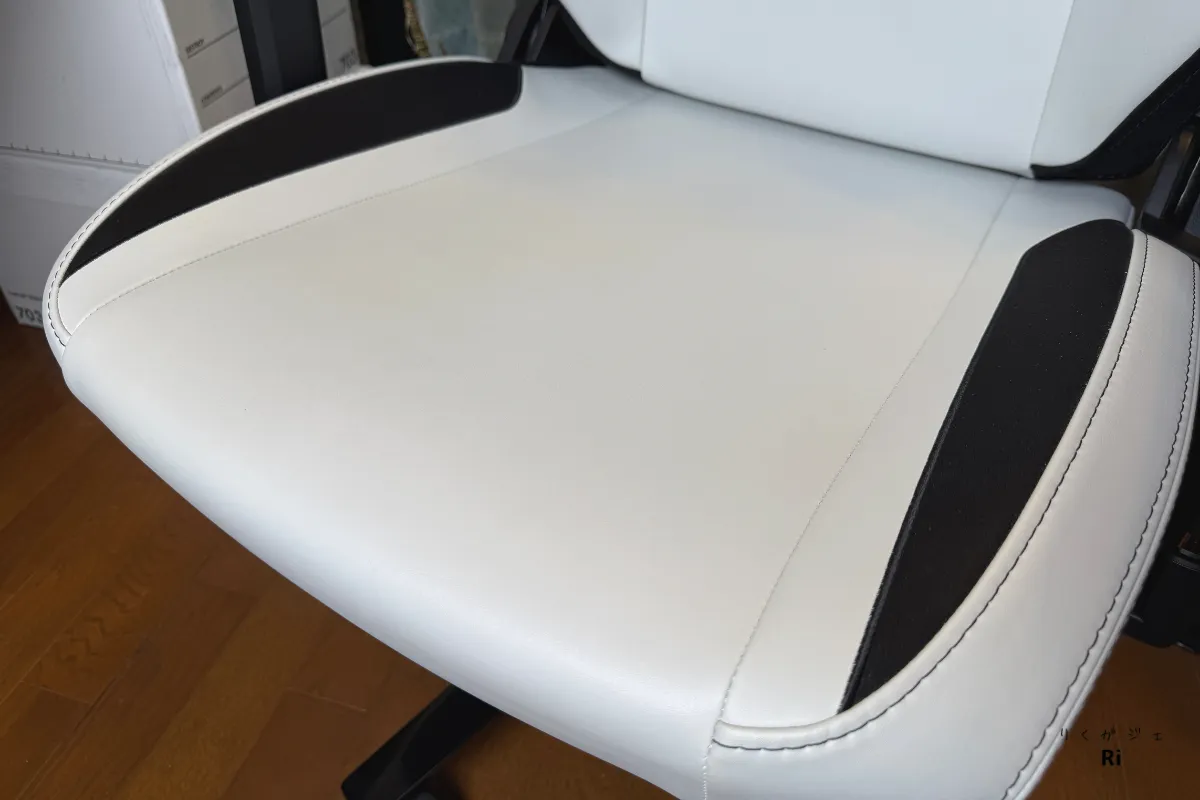 Secretlab TITAN Evoのホワイト×ブラックの座面部分をクローズアップした写真。プレミアムレザーレット素材の質感がわかるショットで、座面と背もたれのカラーが統一され、美しいデザインが強調されている。