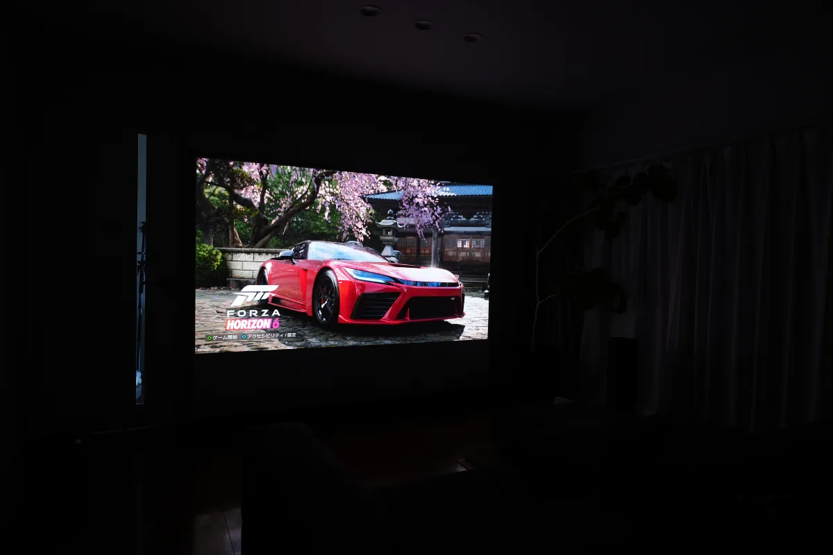 Valerion Pro 2でForza Horizon 6を約100インチの大画面に投影。暗いリビングに赤いスポーツカーのゲーム映像が映し出されている様子。